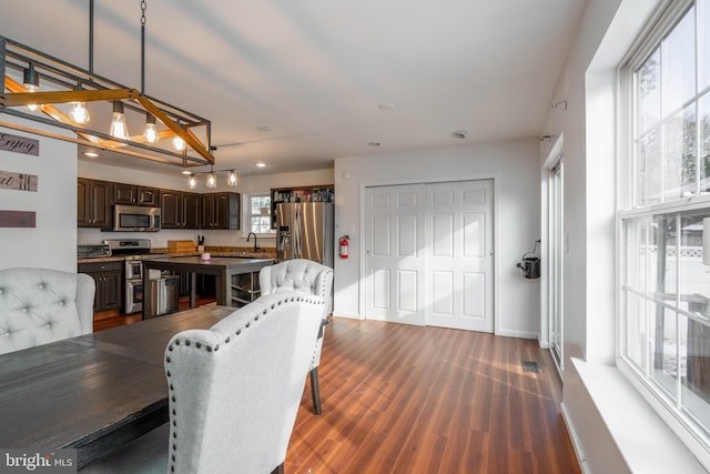 dining area featuring sink, vaulted ceiling, and dark hardwood / wood-style flooring