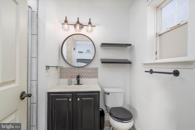 bathroom with decorative backsplash, toilet, and vanity