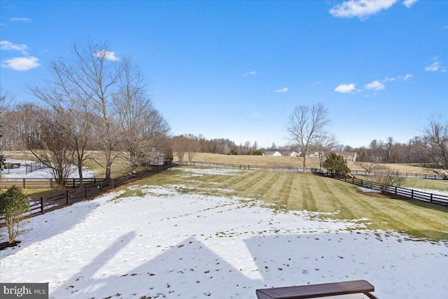 yard covered in snow featuring a rural view