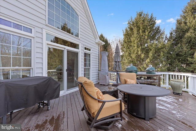 wooden deck with area for grilling and a fire pit