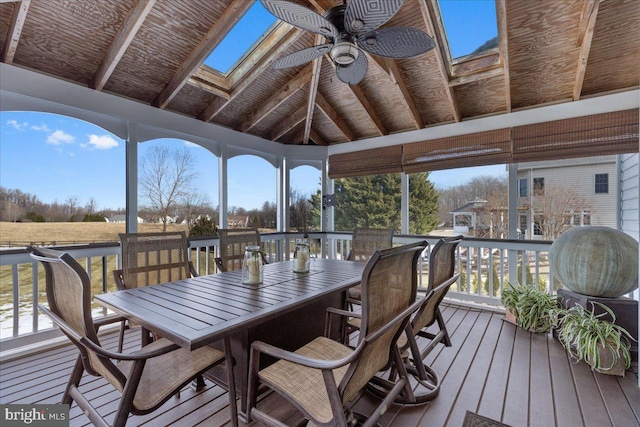 sunroom / solarium featuring vaulted ceiling with skylight and ceiling fan