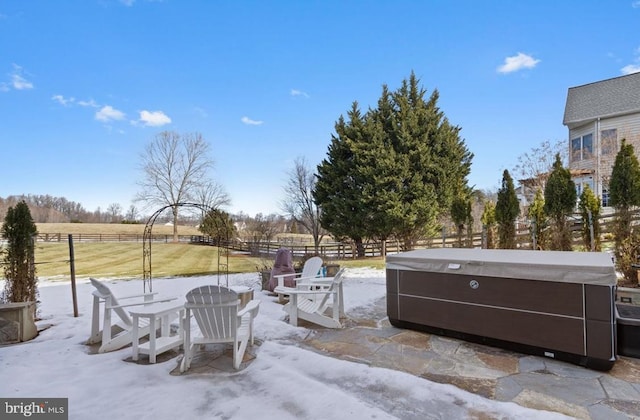 view of patio with a hot tub and a rural view