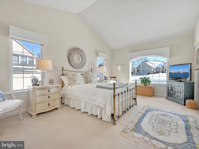 carpeted bedroom featuring high vaulted ceiling and multiple windows