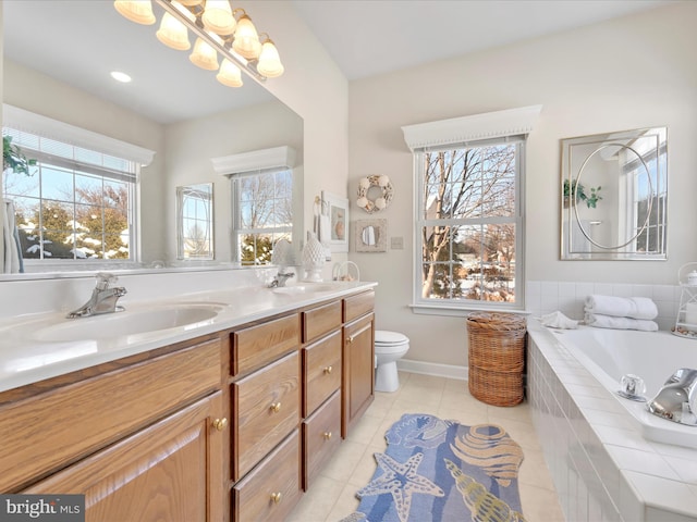 bathroom featuring vanity, toilet, tile patterned flooring, and tiled tub