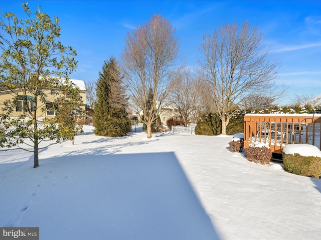 yard covered in snow featuring a wooden deck