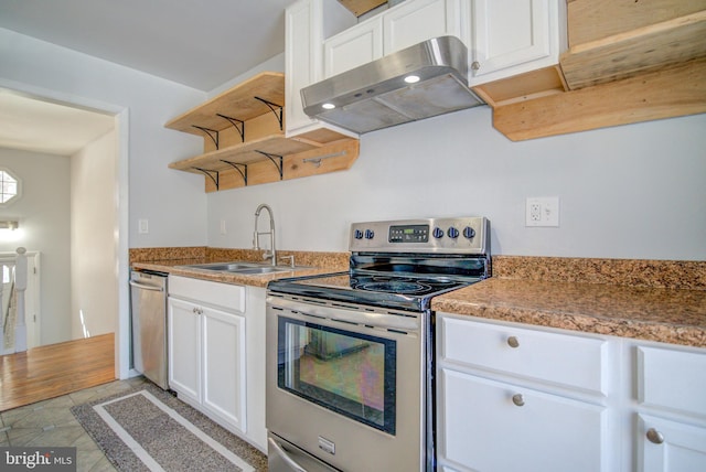 kitchen featuring stainless steel appliances, white cabinetry, sink, and light tile patterned flooring