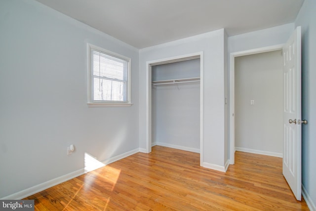 unfurnished bedroom featuring light hardwood / wood-style flooring and a closet