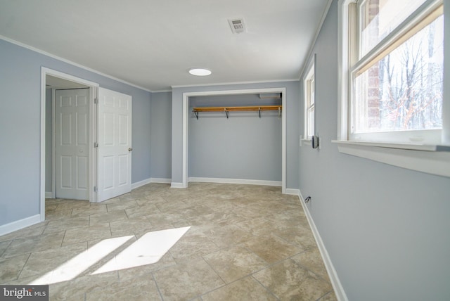 unfurnished bedroom with ornamental molding and a closet