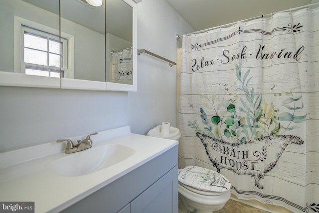 bathroom featuring vanity, toilet, and curtained shower