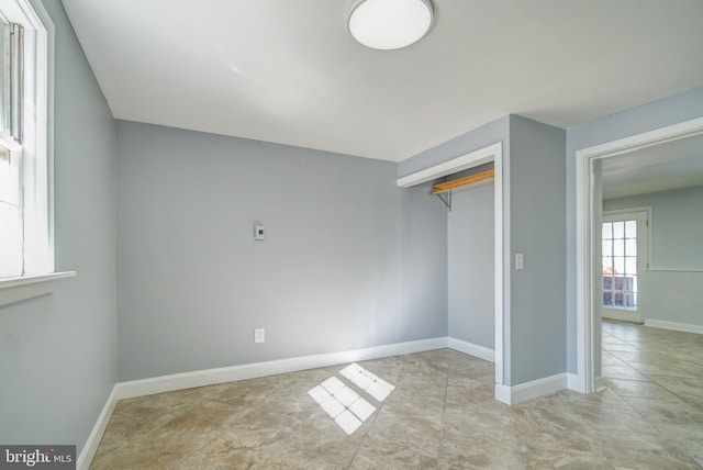 unfurnished bedroom with light tile patterned floors and a closet