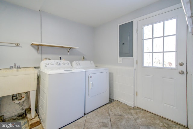 washroom featuring independent washer and dryer, electric panel, sink, and tile walls