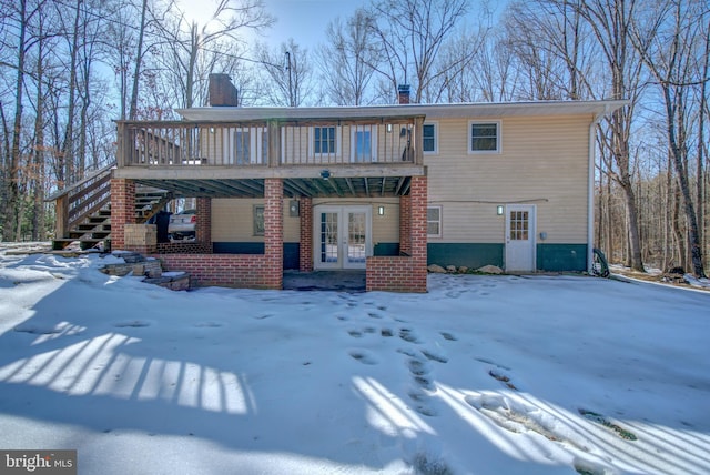 view of front facade with a wooden deck and french doors