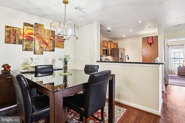 dining area with an inviting chandelier and dark wood-type flooring