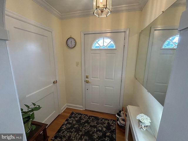 foyer with crown molding, an inviting chandelier, and hardwood / wood-style floors