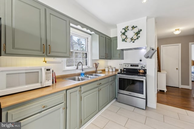 kitchen with light countertops, electric range, a sink, and white microwave