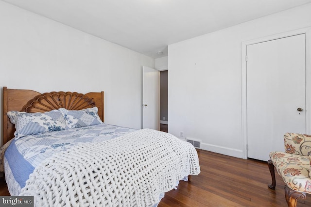 bedroom with visible vents, baseboards, and wood finished floors