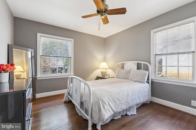 bedroom featuring multiple windows, baseboards, and dark wood-style floors