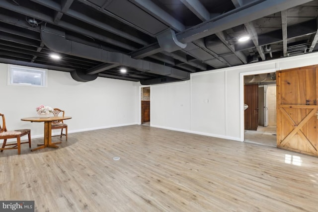 basement with baseboards and wood finished floors
