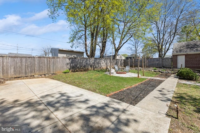view of yard with a patio area, a fenced backyard, and an outdoor fire pit