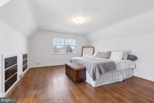 bedroom with baseboards, hardwood / wood-style floors, and vaulted ceiling