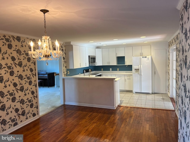 kitchen with white cabinetry, light wood-type flooring, kitchen peninsula, white fridge with ice dispenser, and pendant lighting