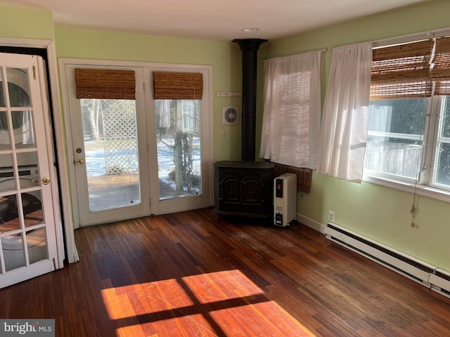 interior space with a baseboard radiator, dark hardwood / wood-style floors, and a wood stove