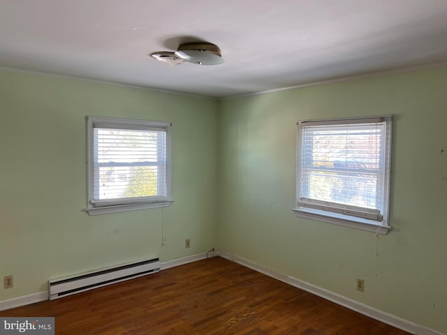 empty room with a baseboard radiator, crown molding, and dark hardwood / wood-style flooring