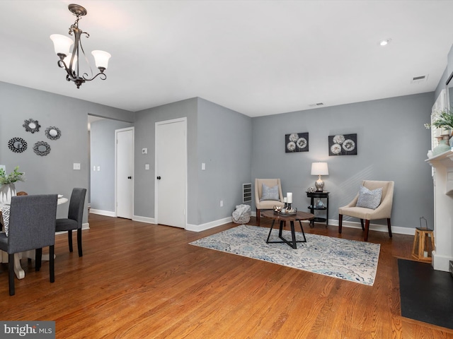 living area featuring dark hardwood / wood-style flooring and an inviting chandelier