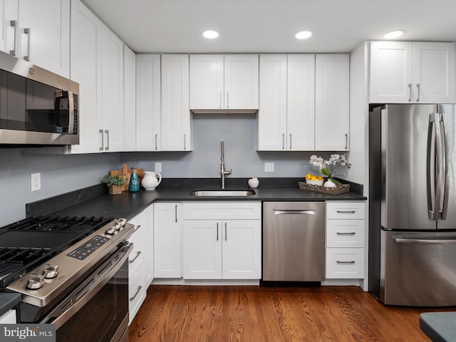 kitchen featuring white cabinetry, appliances with stainless steel finishes, sink, and dark hardwood / wood-style flooring