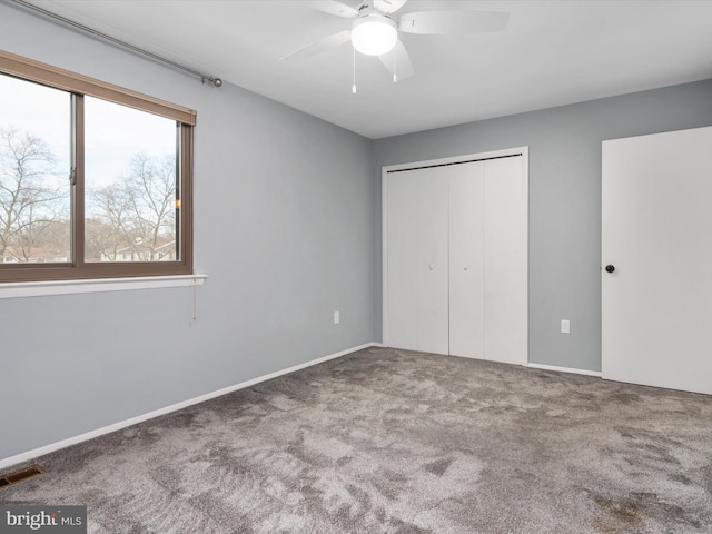 unfurnished bedroom with ceiling fan, a closet, and carpet