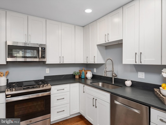 kitchen featuring stainless steel appliances, sink, and white cabinets