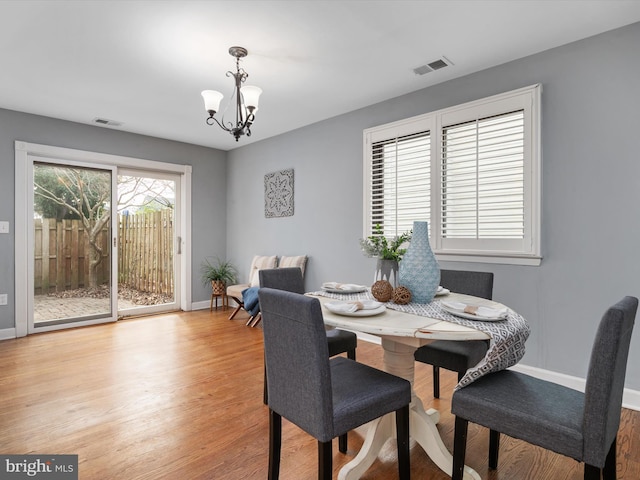 dining space with an inviting chandelier and light hardwood / wood-style floors