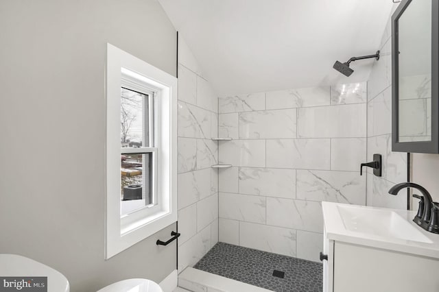 bathroom featuring vanity, toilet, and tiled shower