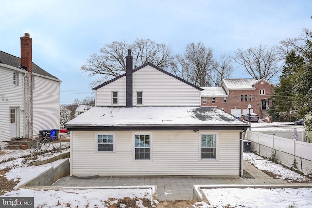 snow covered house featuring cooling unit