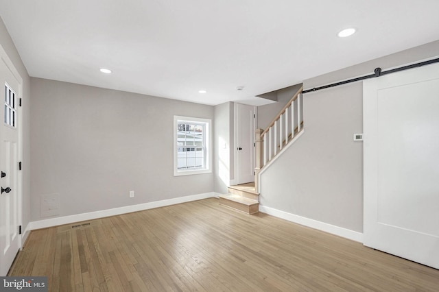 foyer with light wood-type flooring and a barn door