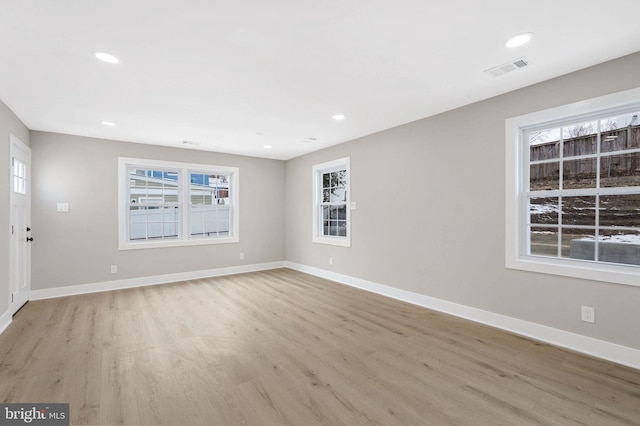 unfurnished room featuring light hardwood / wood-style floors and a wealth of natural light