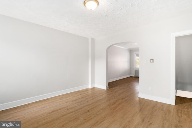 spare room with hardwood / wood-style floors and a textured ceiling