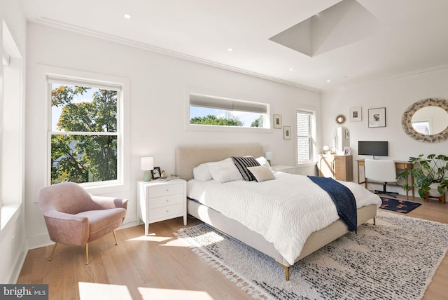 bedroom featuring ornamental molding and light hardwood / wood-style flooring