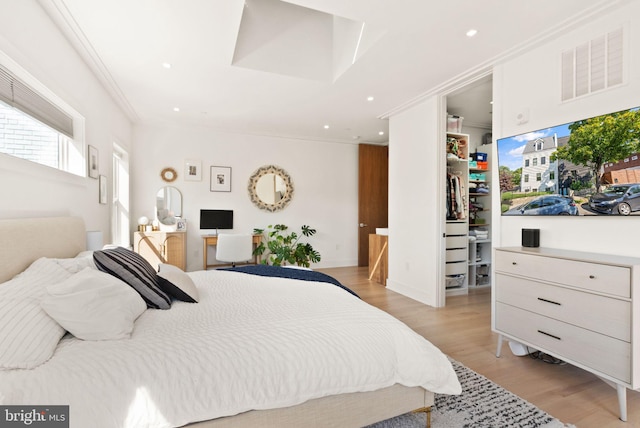 bedroom with crown molding and light hardwood / wood-style floors