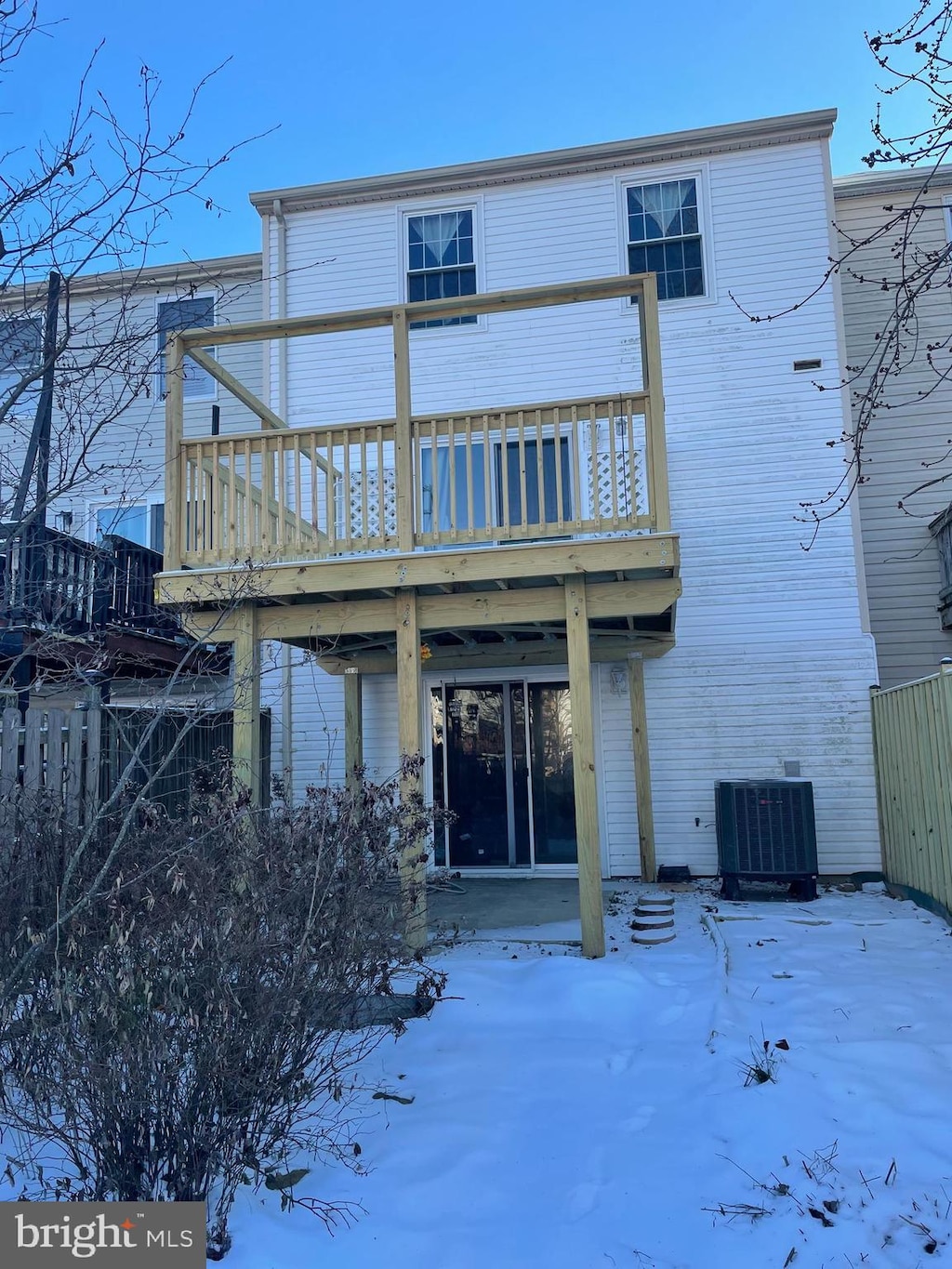 snow covered property featuring central AC and a deck