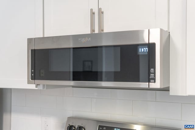 room details featuring backsplash and white cabinetry