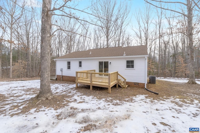 snow covered property with a deck and cooling unit