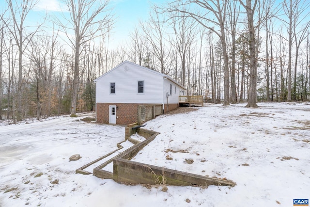 view of snow covered exterior featuring a wooden deck