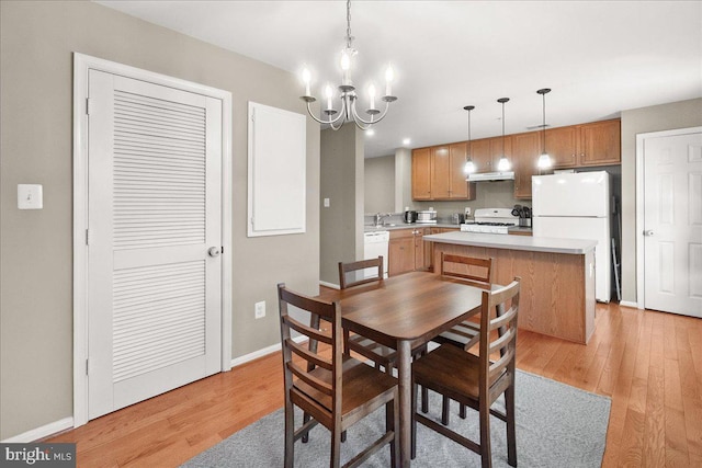 dining space featuring an inviting chandelier and light hardwood / wood-style flooring