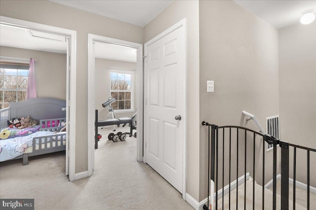 hallway with light carpet and a wealth of natural light