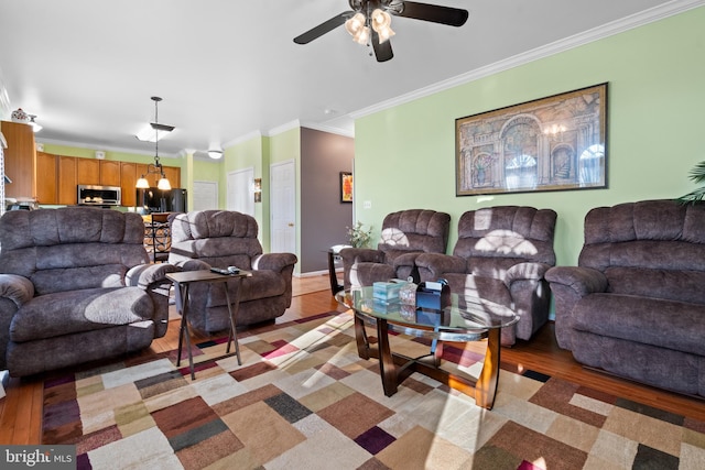 living room featuring ceiling fan, ornamental molding, and light hardwood / wood-style flooring