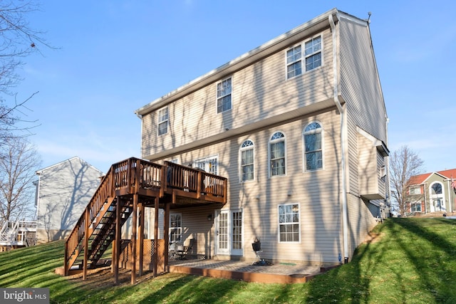 rear view of property featuring a wooden deck, a yard, and a patio area