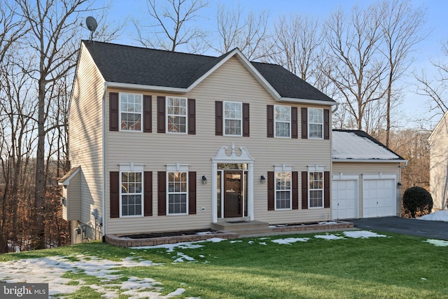 colonial-style house with a garage and a front lawn