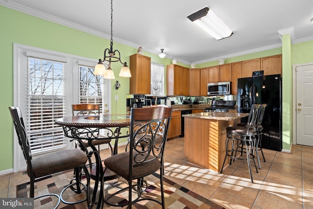 kitchen with light stone counters, crown molding, decorative light fixtures, a center island, and black appliances