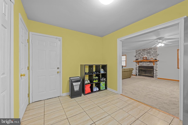 miscellaneous room featuring ceiling fan, a fireplace, and light carpet